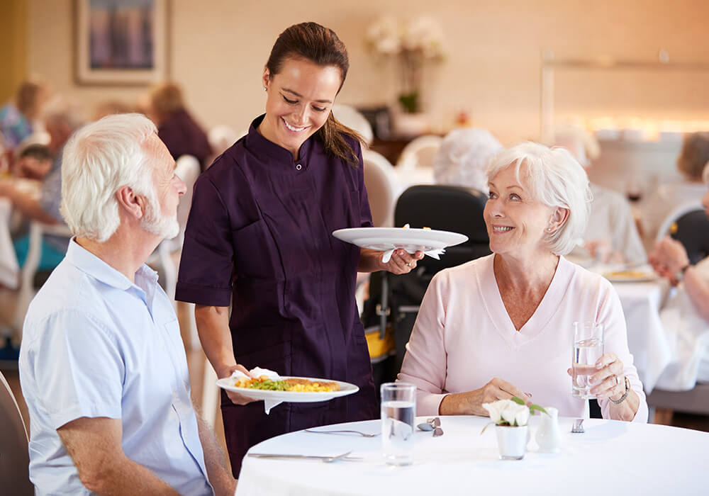 Senior couple being served dinner