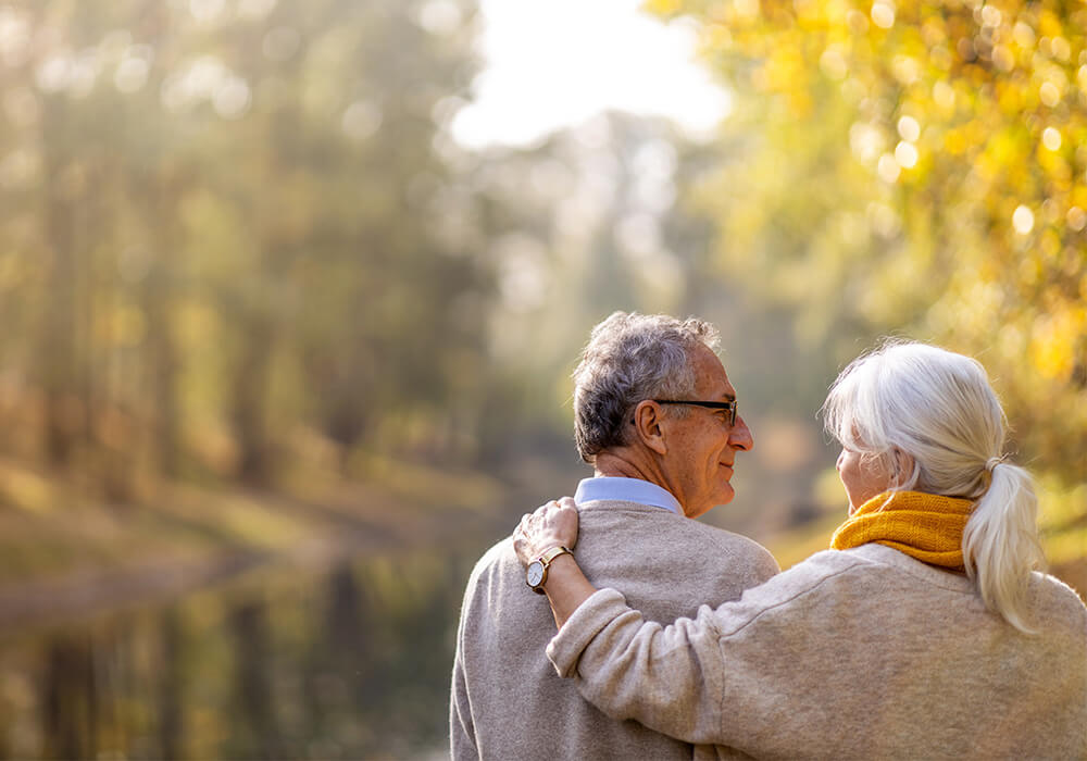 Senior couple hold each other during nature walk